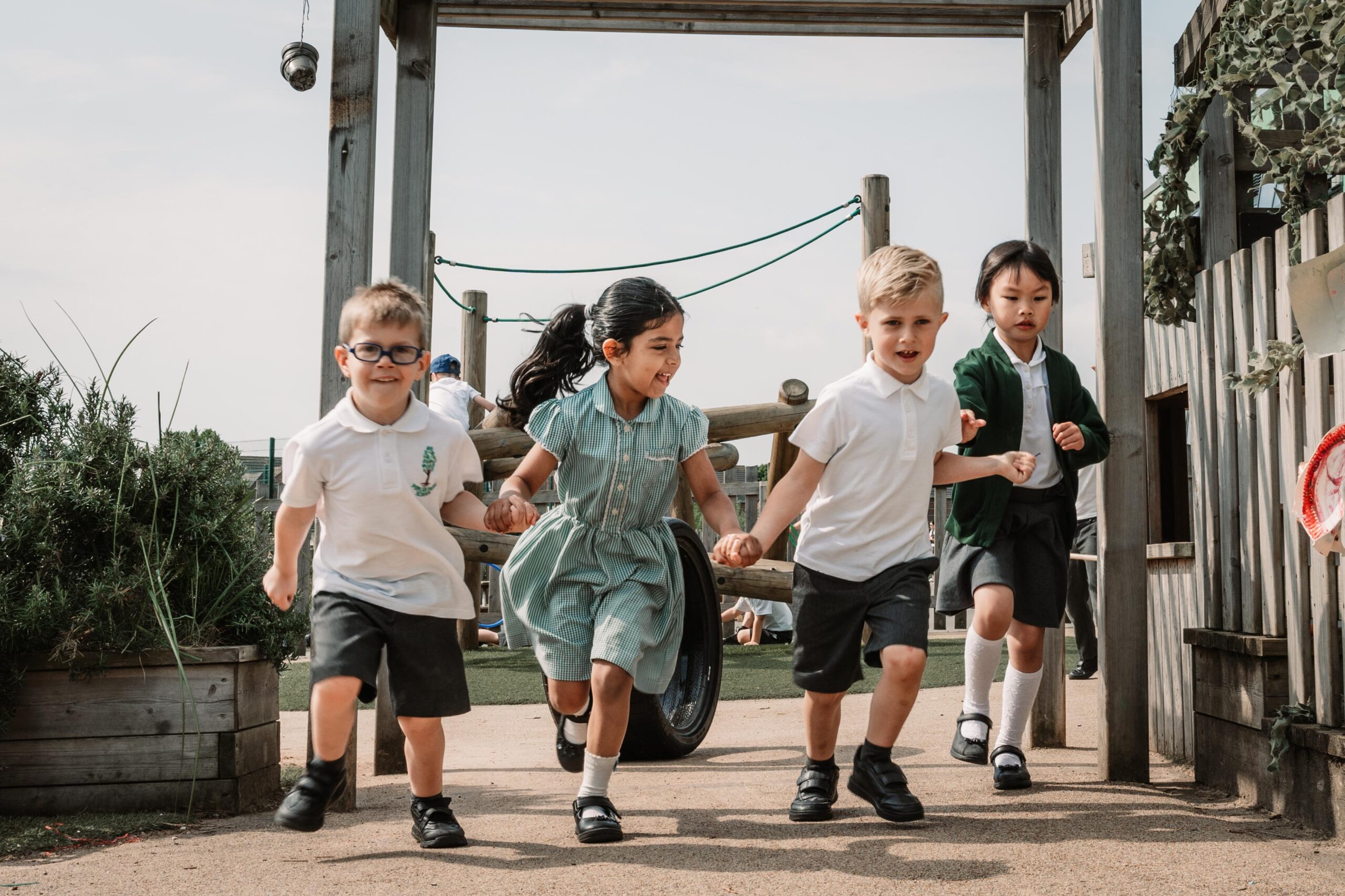 children running and playing in the outdoor EYFS area